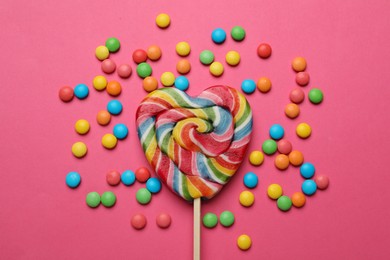 Many different tasty candies on pink background, flat lay