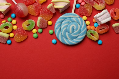 Photo of Many different tasty candies and marshmallows on red background, flat lay. Space for text