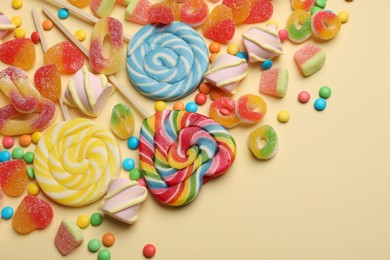 Photo of Many different tasty candies and marshmallows on beige background, flat lay. Space for text