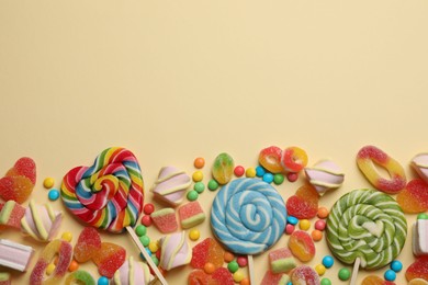 Photo of Many different tasty candies and marshmallows on beige background, flat lay. Space for text