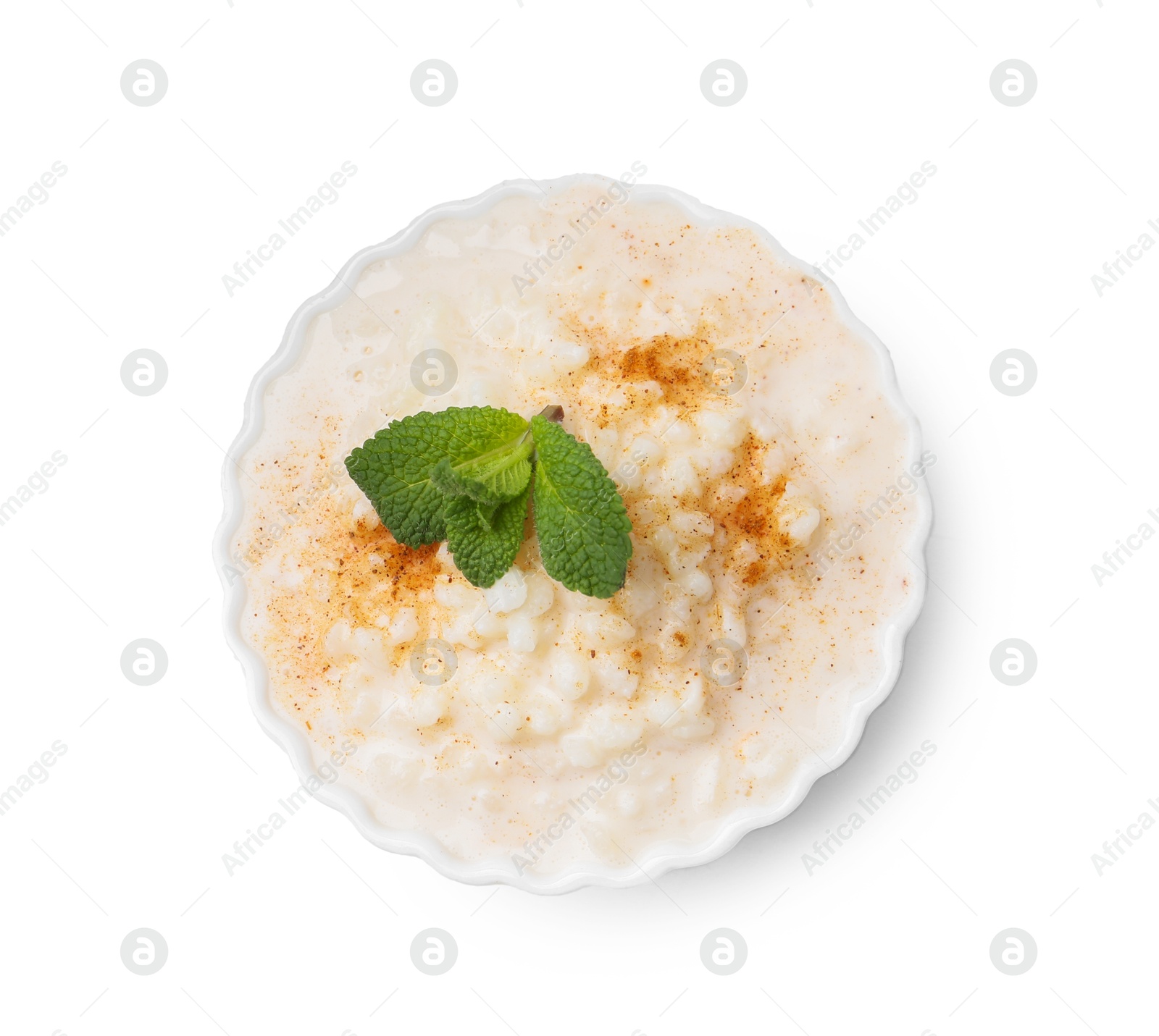 Photo of Tasty rice pudding with cinnamon and mint in bowl isolated on white, top view