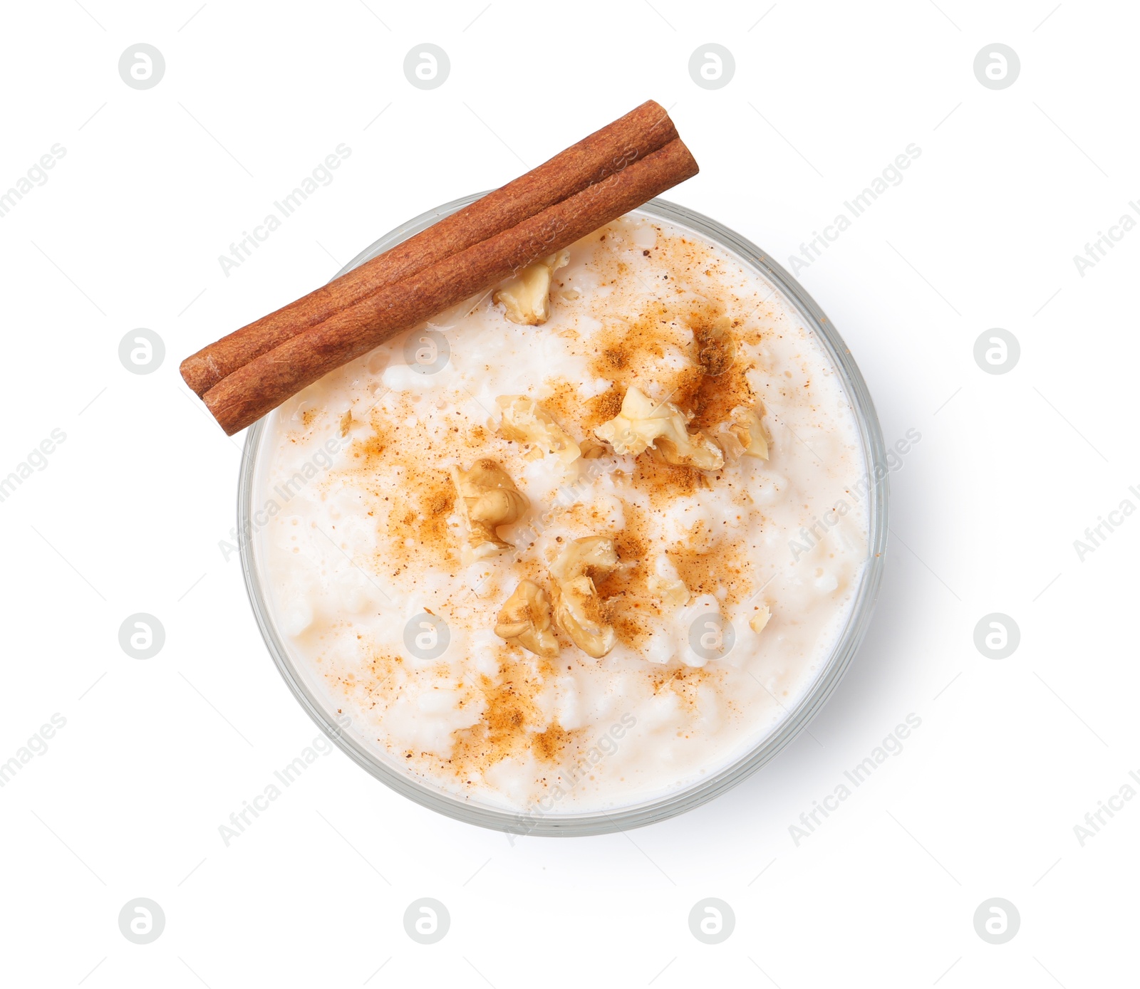 Photo of Tasty rice pudding with cinnamon and nuts in glass bowl isolated on white, top view