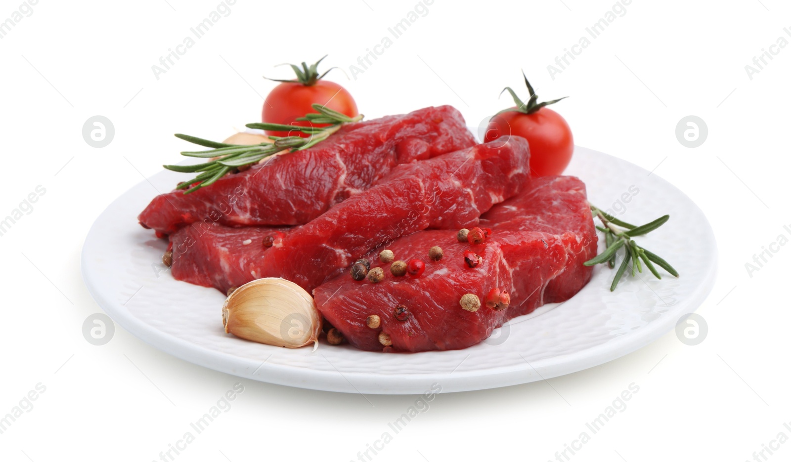 Photo of Pieces of raw beef meat, spices and tomatoes isolated on white