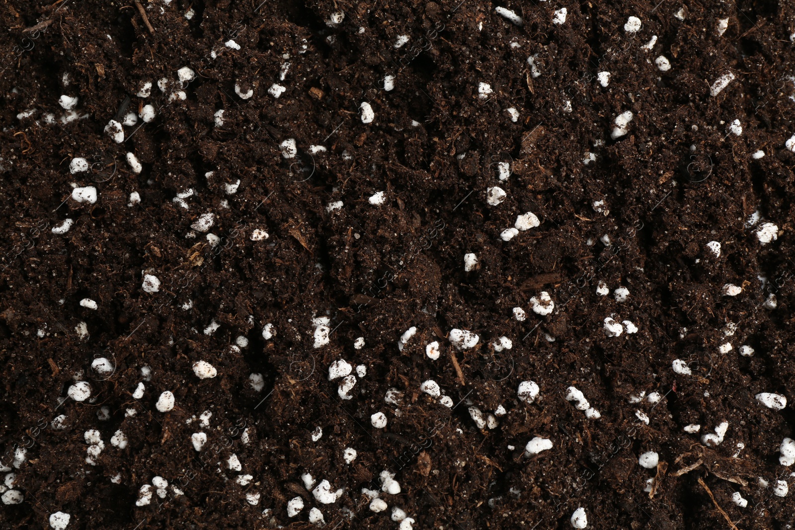 Photo of Fresh soil with fertilizer as background, closeup