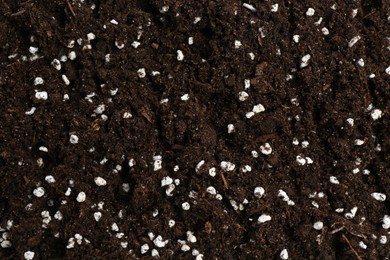 Photo of Fresh soil with fertilizer as background, closeup