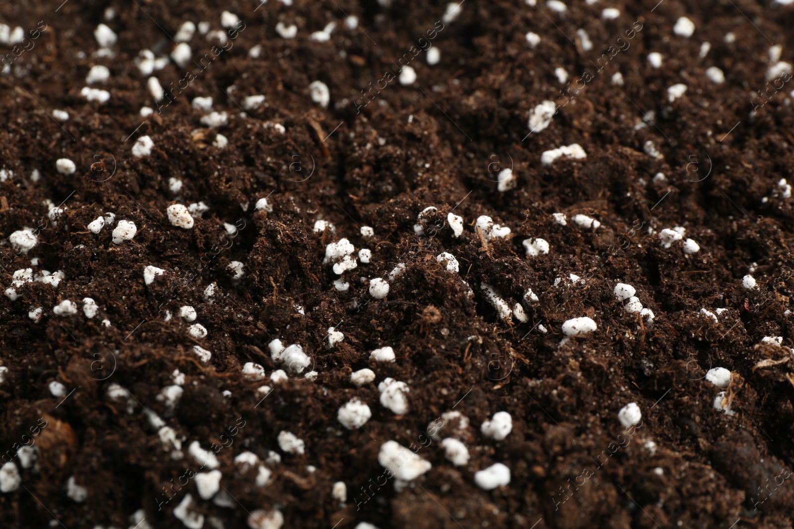 Photo of Fresh soil with fertilizer as background, closeup