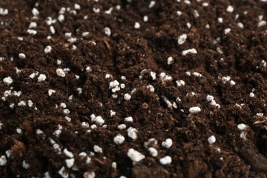 Photo of Fresh soil with fertilizer as background, closeup