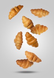 Image of Delicious croissants falling on grey background. Puff pastry