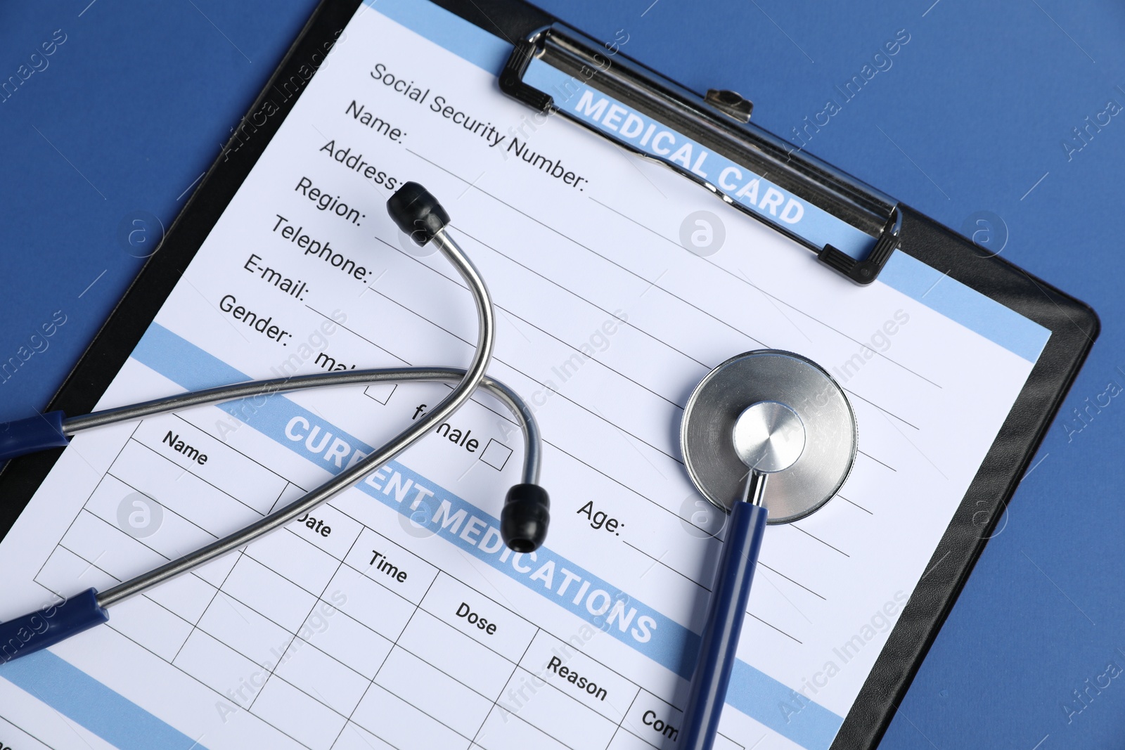Stethoscope and medical card form on blue background, top view Photo of Stethoscope and medical card form on blue background, top view