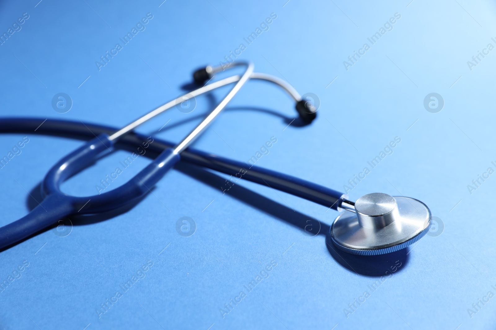 Stethoscope on blue background, closeup. Medical tool Photo of Stethoscope on blue background, closeup. Medical tool