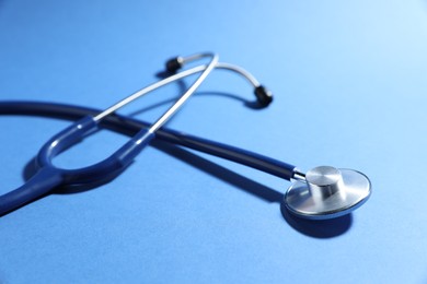 Photo of Stethoscope on blue background, closeup. Medical tool