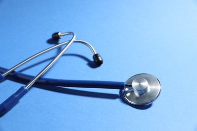 Stethoscope on blue background, closeup. Medical tool