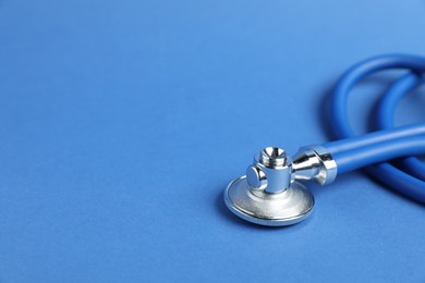 Photo of Stethoscope on blue background, closeup. Space for text