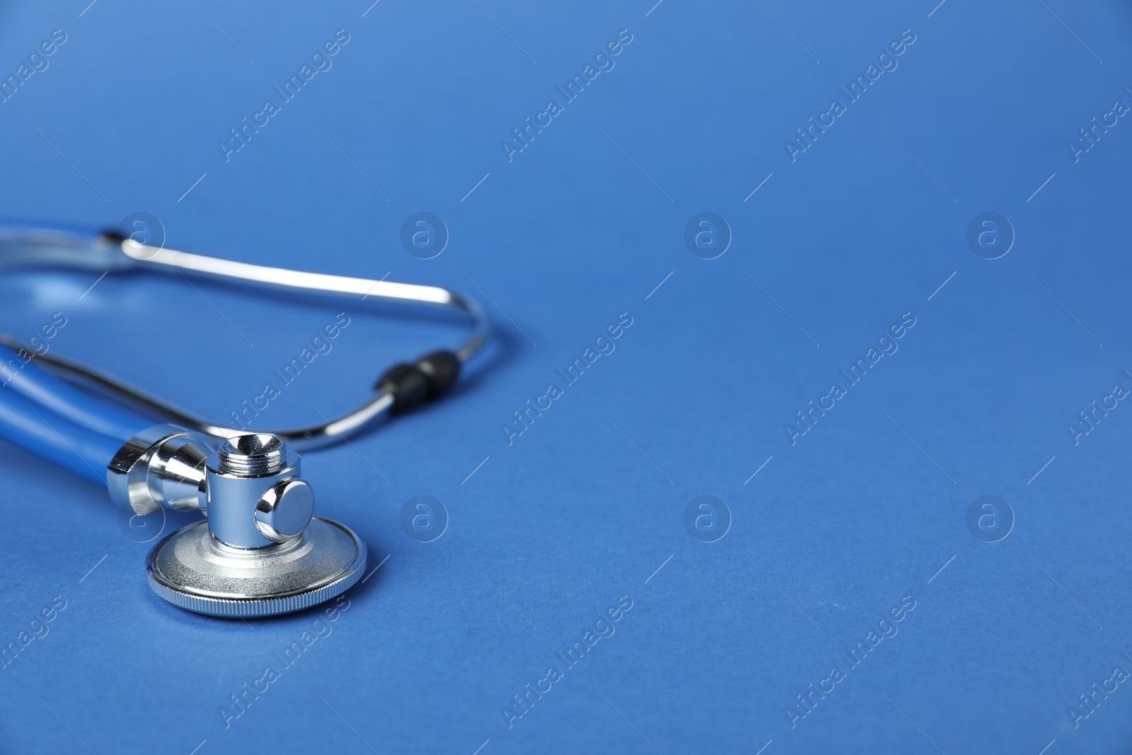 Stethoscope on blue background, closeup. Space for text Photo of Stethoscope on blue background, closeup. Space for text