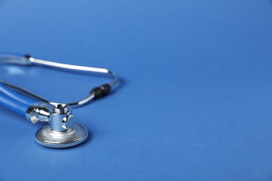 Photo of Stethoscope on blue background, closeup. Space for text
