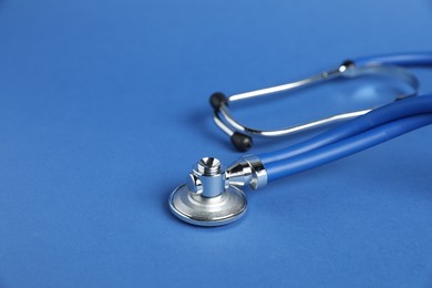 Photo of Stethoscope on blue background, closeup. Space for text