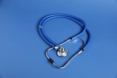 Photo of Stethoscope on blue background, above view. Medical tool