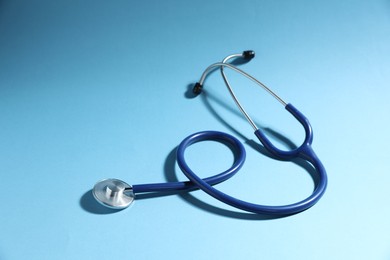 Photo of Stethoscope on light blue background. Medical tool