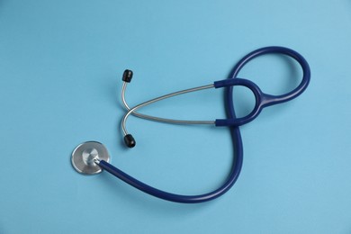 Photo of Stethoscope on light blue background, top view