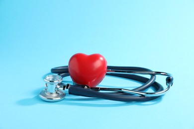 Photo of Stethoscope and red decorative heart on light background