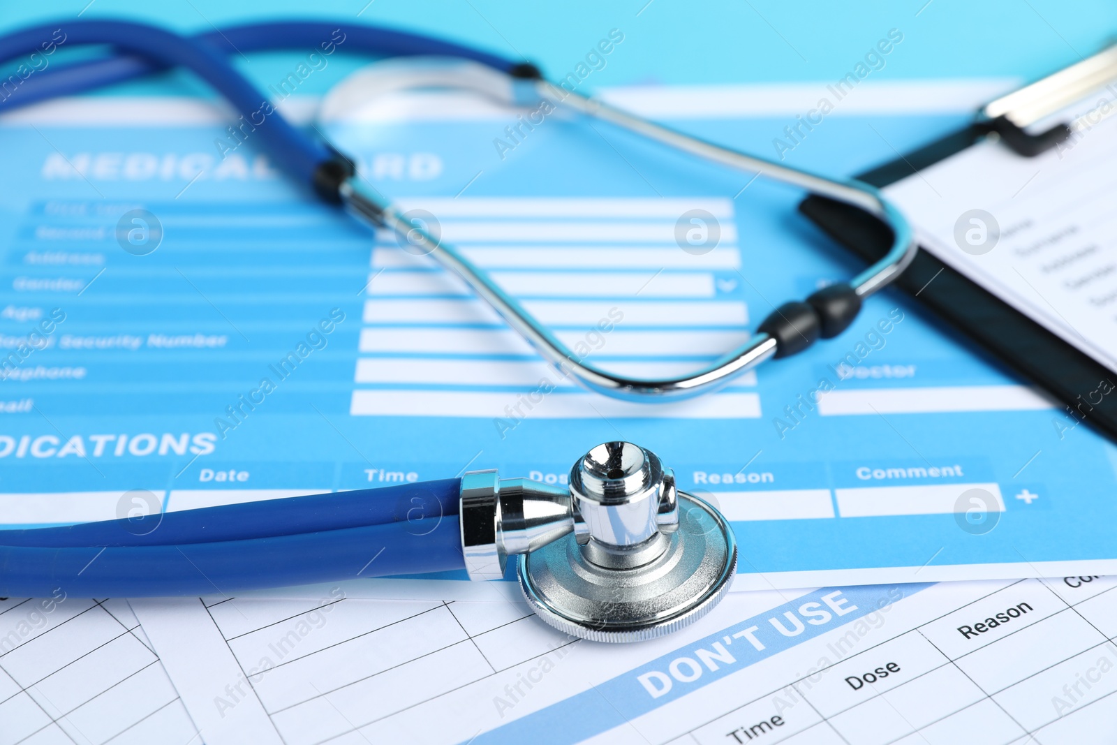 Stethoscope and medical card forms on table, closeup Photo of Stethoscope and medical card forms on table, closeup
