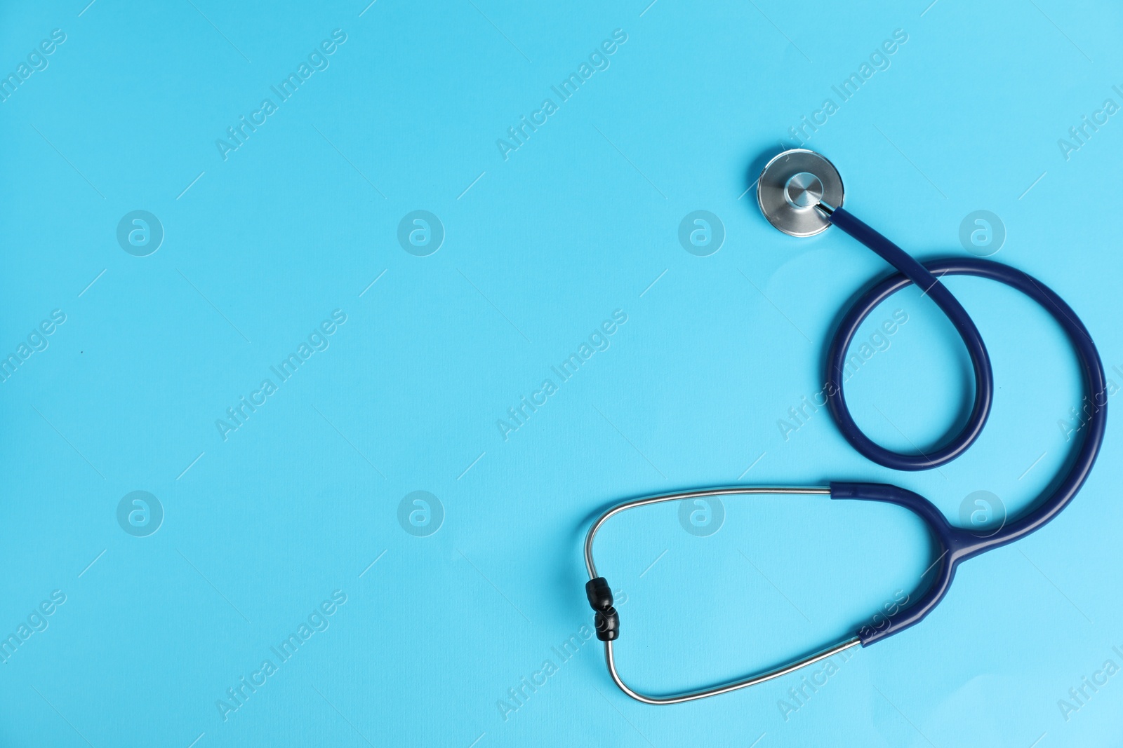 Stethoscope on light blue background, top view. Space for text Photo of Stethoscope on light blue background, top view. Space for text