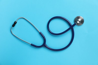 Photo of Stethoscope on light blue background, top view