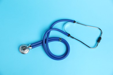 Photo of Stethoscope on light blue background, top view