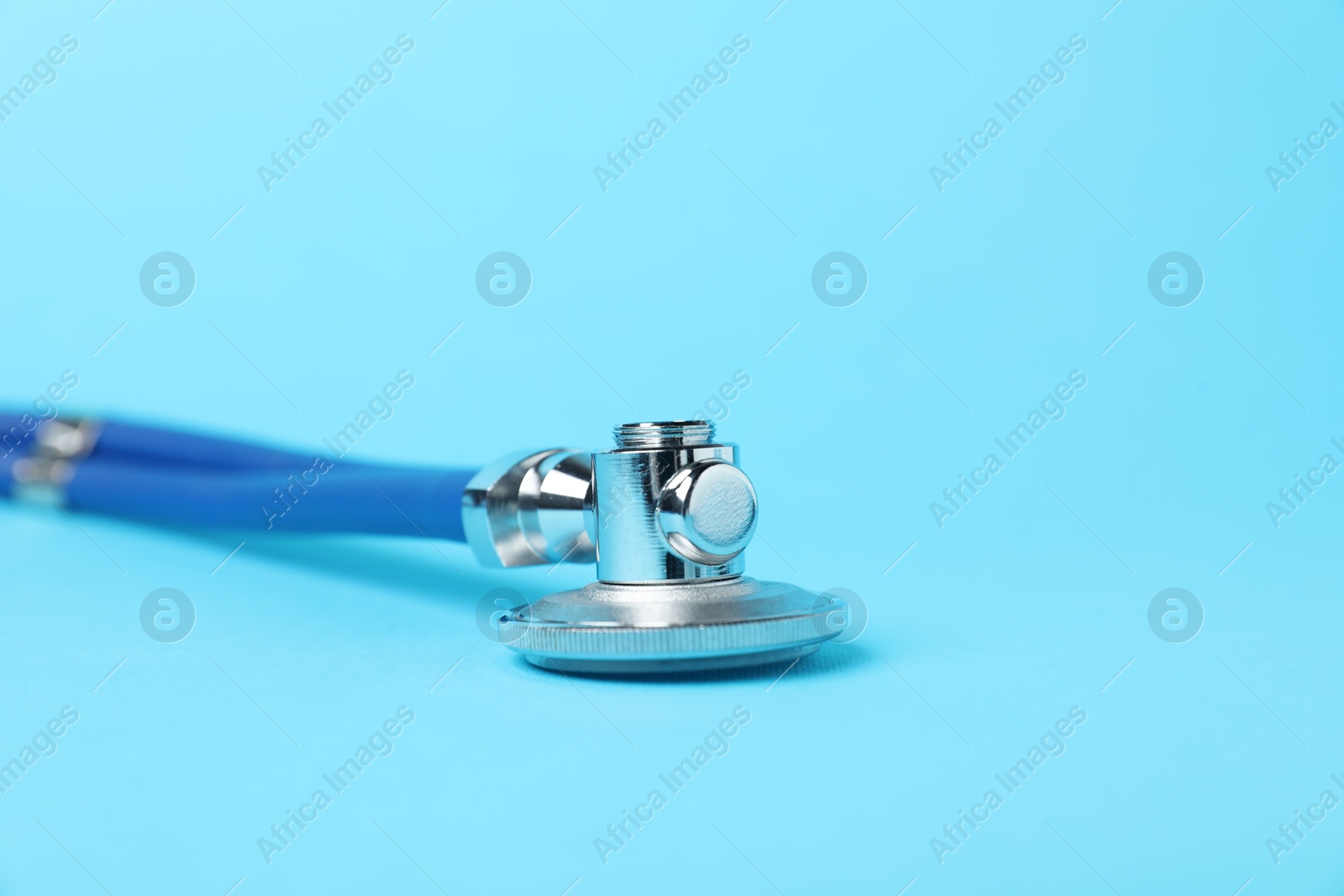 Stethoscope on light blue background, closeup. Space for text Photo of Stethoscope on light blue background, closeup. Space for text