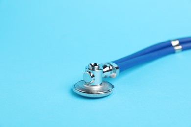 Photo of Stethoscope on light blue background, closeup. Space for text