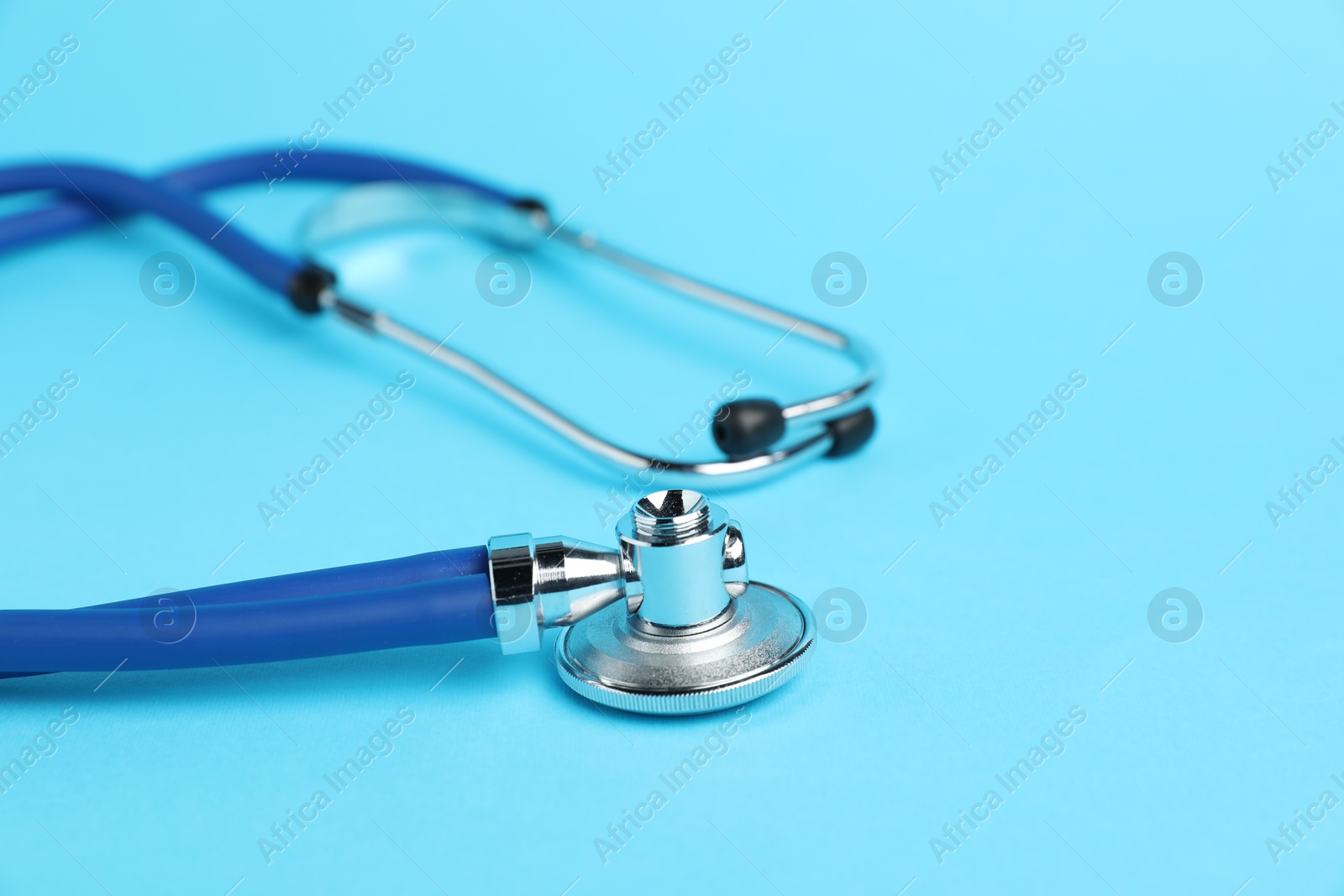 Stethoscope on light blue background, closeup. Space for text Photo of Stethoscope on light blue background, closeup. Space for text