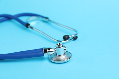 Photo of Stethoscope on light blue background, closeup. Space for text