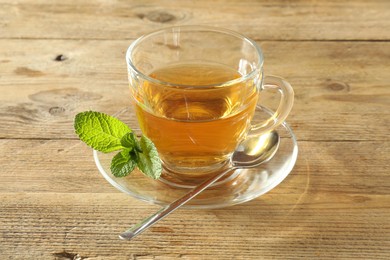 Photo of Freshly brewed tea in glass cup on wooden table
