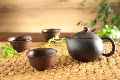 Photo of Freshly brewed tea in ceramic cups and teapot on table