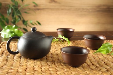Photo of Freshly brewed tea in ceramic cups and teapot on table