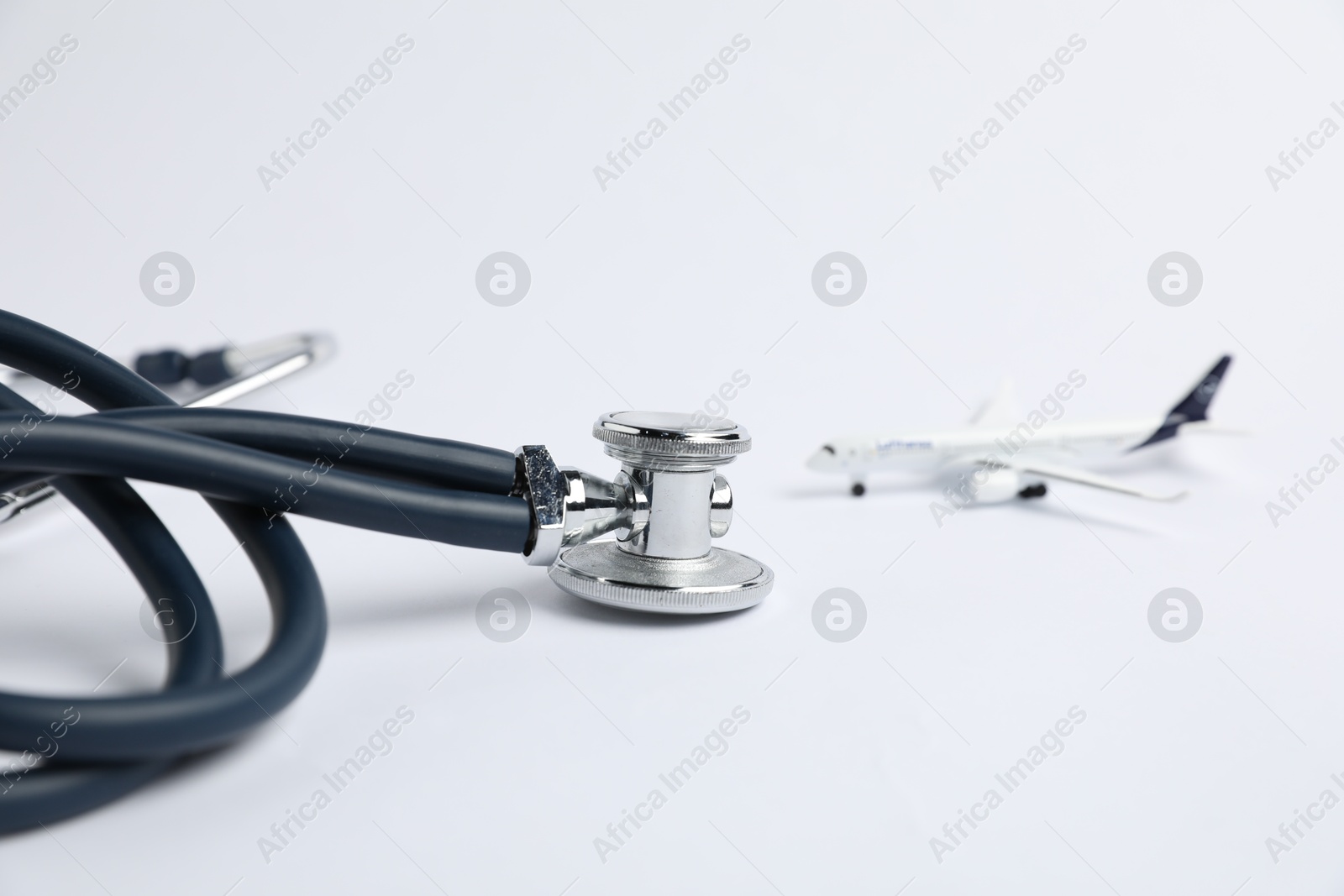 Stethoscope and airplane model on light background, selective focus Photo of Stethoscope and airplane model on light background, selective focus