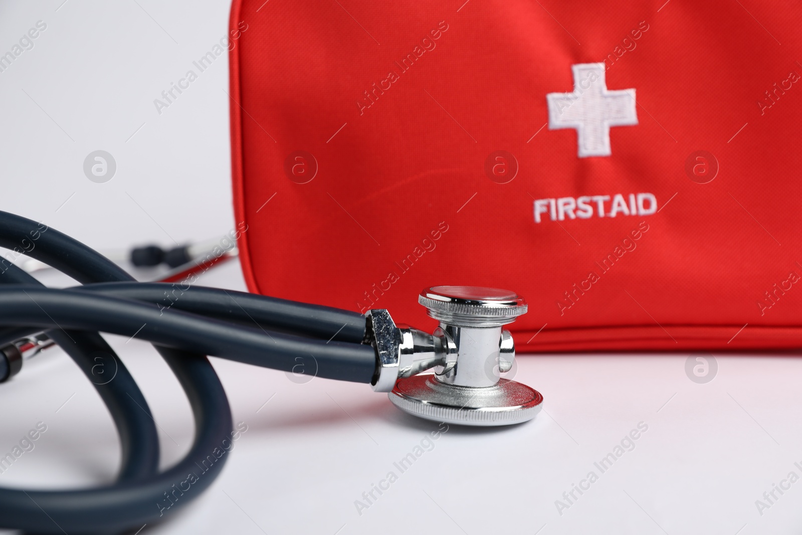 Stethoscope and first aid kit on light background, closeup Photo of Stethoscope and first aid kit on light background, closeup