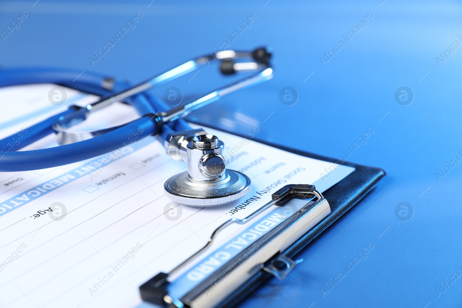 Stethoscope and medical card form on blue background, closeup Photo of Stethoscope and medical card form on blue background, closeup