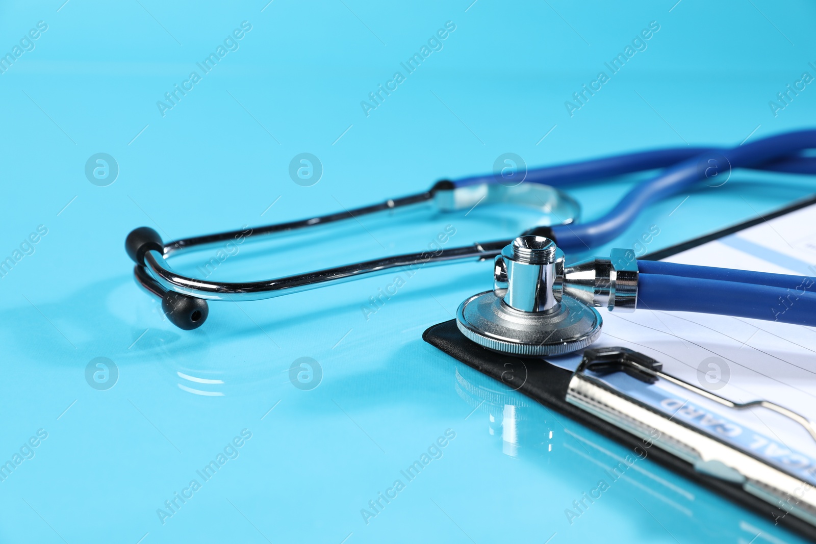 Stethoscope and medical card form on light blue background, closeup Photo of Stethoscope and medical card form on light blue background, closeup