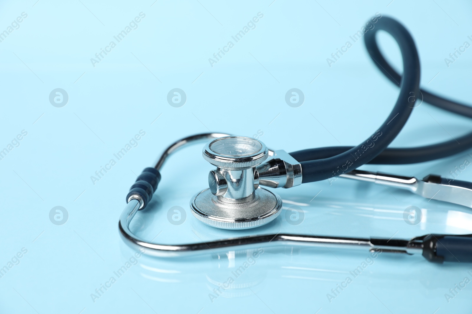 Stethoscope on light blue background, closeup. Medical tool Photo of Stethoscope on light blue background, closeup. Medical tool