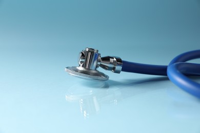 Photo of Stethoscope on light blue background, closeup. Space for text