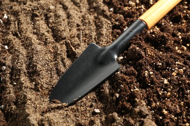 Photo of Shovel in fresh soil, closeup. Gardening tool