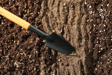 Photo of Shovel in fresh soil, closeup. Gardening tool