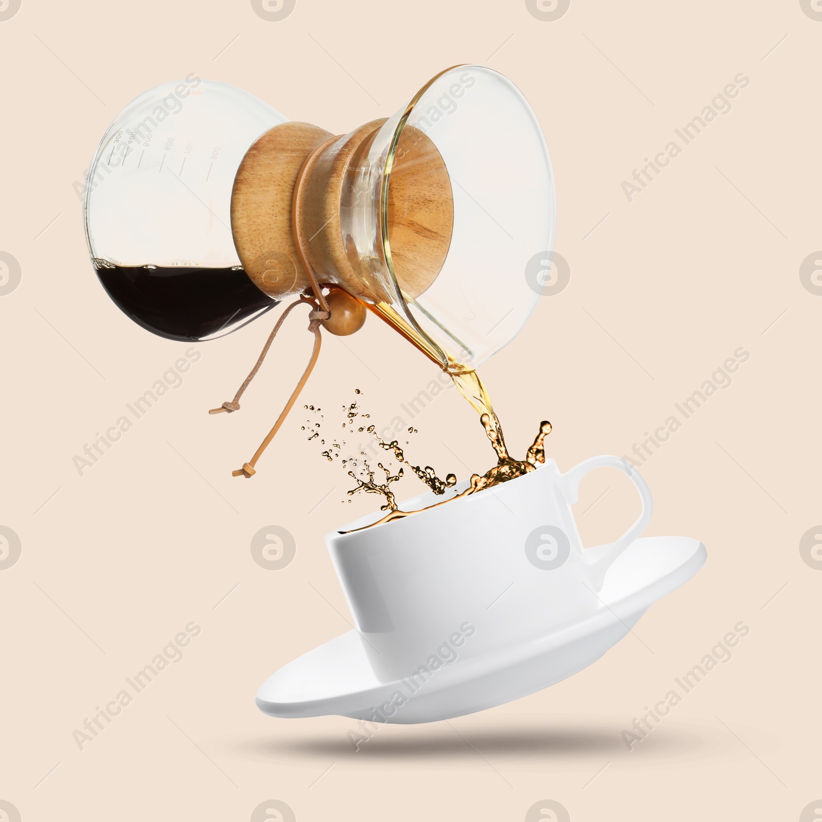 Image of Pouring freshly brewed coffee from glass coffeemaker into cup on pink beige background