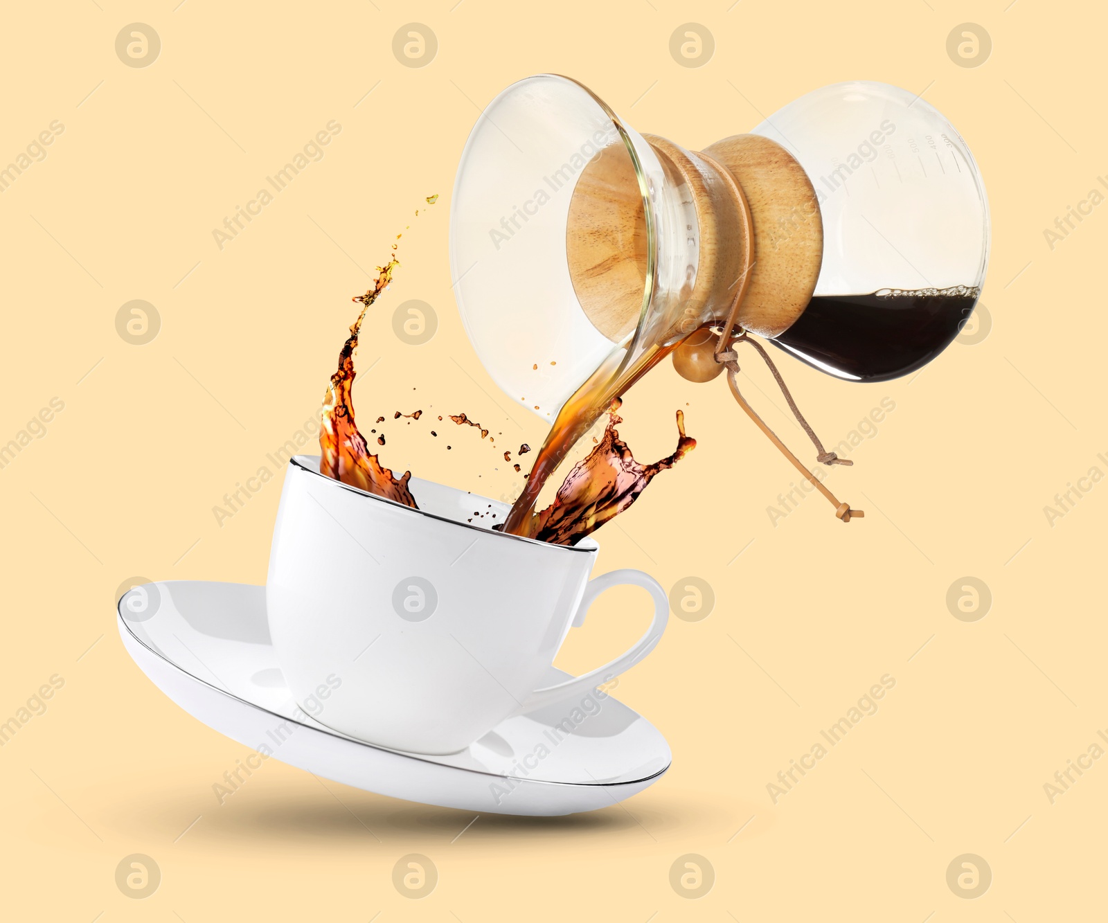 Image of Pouring freshly brewed coffee from glass coffeemaker into cup on beige background