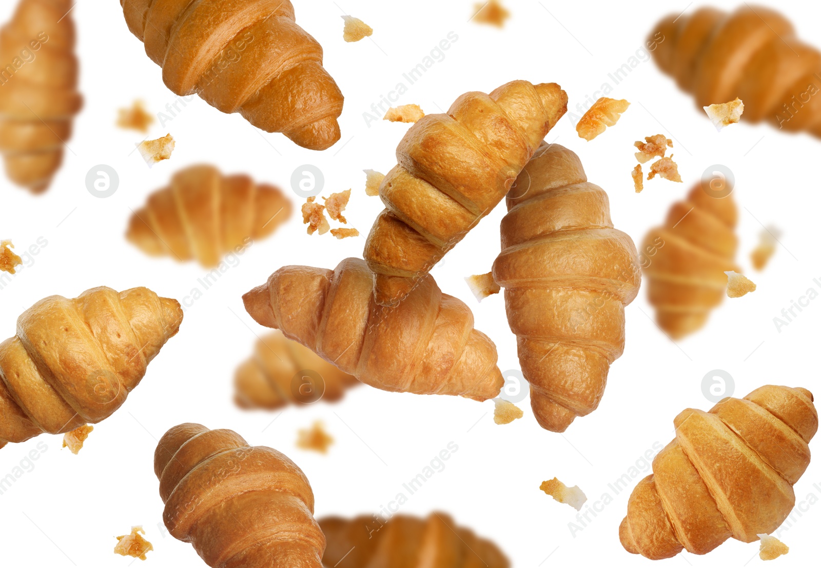 Image of Delicious croissants and crumbs in air on white background. Puff pastry