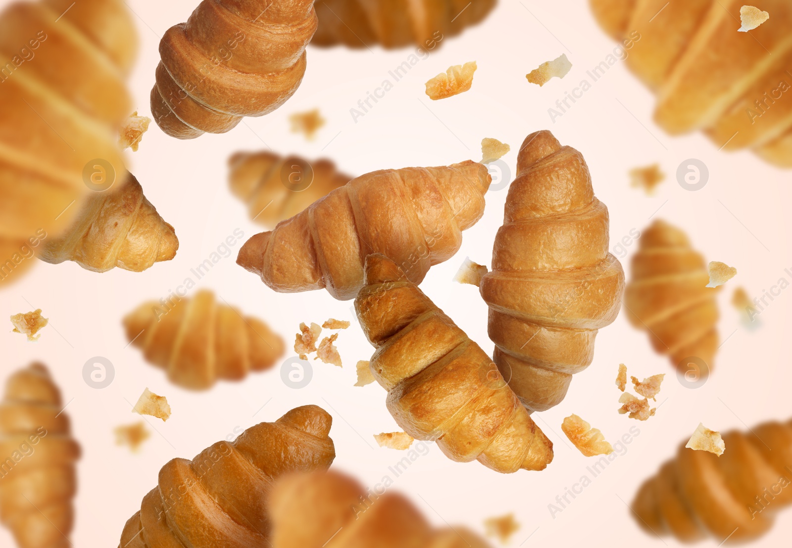 Image of Delicious croissants and crumbs in air on white background. Puff pastry