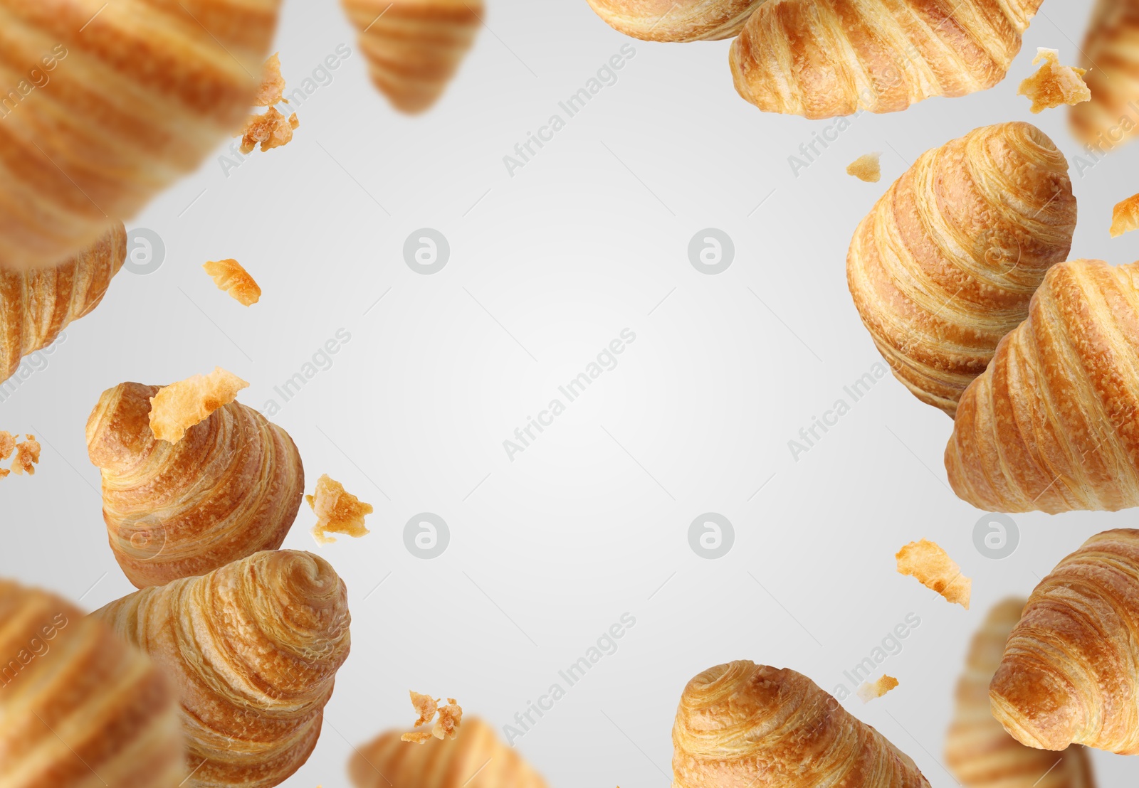 Image of Delicious croissants and crumbs in air on grey background. Puff pastry