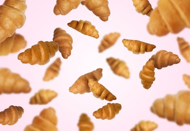 Image of Delicious croissants in air on pink background. Puff pastry