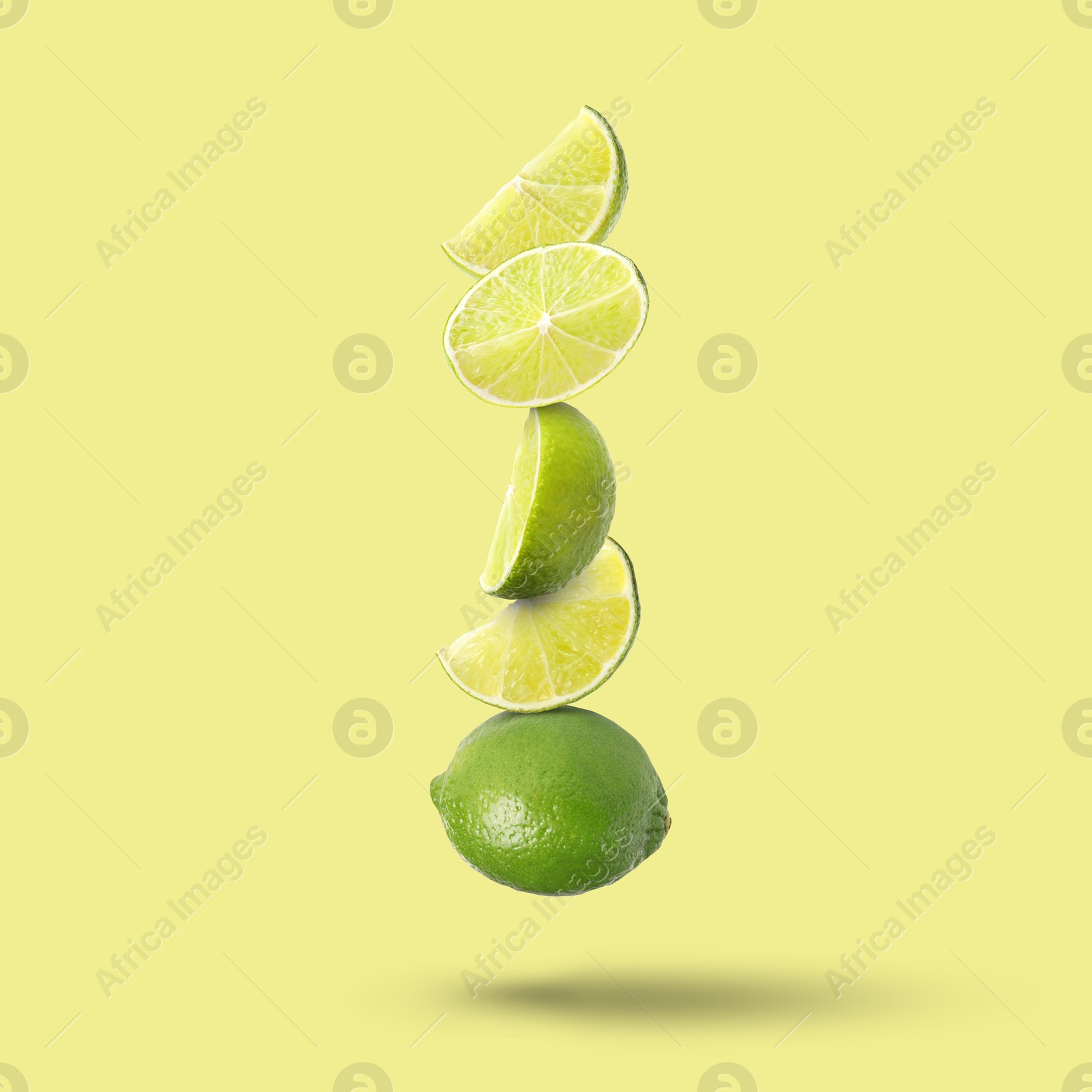 Image of Fresh juicy limes falling on beige background